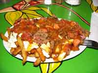 canada - qu�bec - Une adaptation de la poutine : la sp&eacute;cialit&eacute; qu&eacute;b&eacute;coise.  
Ici aussi je vais reprendre les informations que m a donn&eacute; Bruno : "La poutine que vous avez montr&eacute; sur votre site est...  Bien, en fait, je ne sais m&ecirc;me pas ce que c est car le v&eacute;ritable plat est en fait constitu&eacute; de frites, d une sauce de style gravy et de fromage.  On d&eacute;nombre cependant de tr&egrave;s nombreuses variantes dont la poutine au foie gras, la poutine italienne (avec de la sauce tomate), poutine au poulet, etc.  Aussi, une autre pr&eacute;cision : oui, il y a les poutine particuli&egrave;rement grasses qu on retrouve dans les "fast food", mais il y a aussi celles qu on trouve dans les restaurant moyens.  Celle-ci est moins grasse et plus go&ucirc;teuse.  Si vous revenez, essayez celle de St-Hubert, elle illustre bien la diff&eacute;rence par rapport &agrave; celle de, par exemple, la cha&icirc;ne de restauration rapide nomm&eacute;e "la belle province".  Cependant, un autre conseil &agrave; ce niveau, prenez-en une pour deux personne, les portions sont souvent exag&eacute;r&eacute;es."